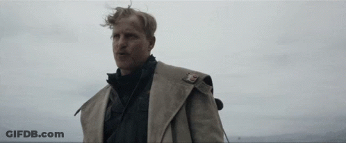 A Man In A Trench Coat With A Badge On His Shoulder GIF