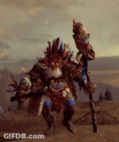 A Man In A Tribal Costume Is Holding A Stick GIF
