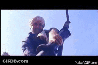 A Man In A Turban Is Holding A Large Sword In His Hand . GIF