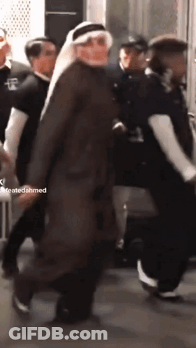 A Man In A Turban Is Walking In A Crowd Of People With A Caption That Says Createdahmed GIF