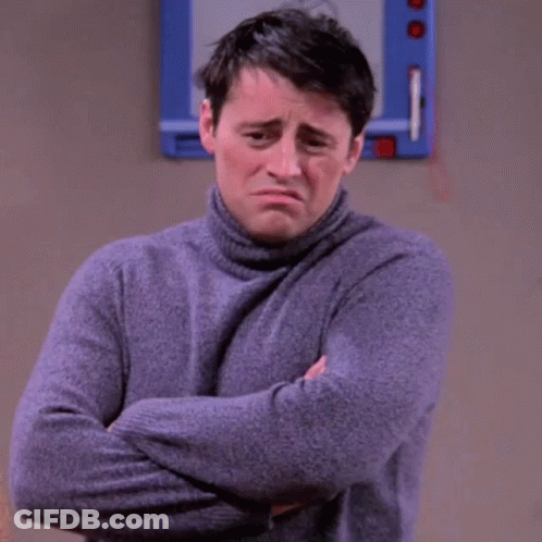A Man In A Turtleneck Sweater Is Standing With His Arms Crossed . GIF