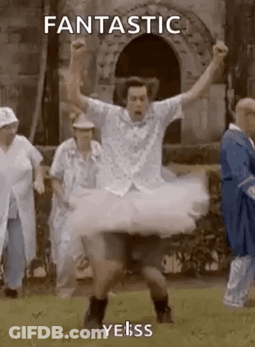A Man In A Tutu Is Dancing In A Field With His Arms In The Air . GIF