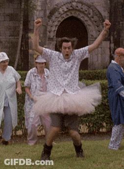 A Man In A Tutu Is Dancing In A Field With Other People GIF