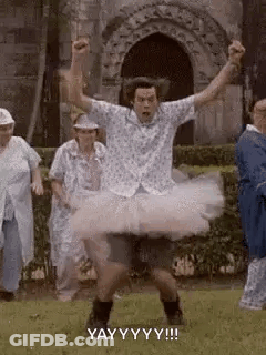 A Man In A Tutu Is Dancing In Front Of A Group Of Elderly People . GIF
