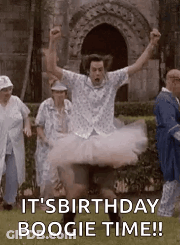 A Man In A Tutu Is Jumping In The Air While A Group Of People Are Standing Behind Him . GIF
