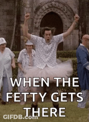 A Man In A Tutu Is Jumping In The Air While A Group Of People Are Standing Behind Him . GIF