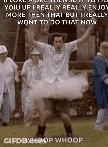 A Man In A Tutu Is Jumping In The Air While A Group Of People Watch . GIF