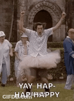 A Man In A Tutu Is Jumping In The Air While A Group Of People Watch . GIF