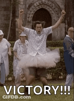 A Man In A Tutu Is Jumping In The Air With His Arms In The Air In Front Of A Group Of People . GIF