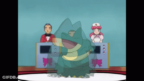 A Man In A Tuxedo And A Woman In A Pink Dress Are Behind A Frog GIF