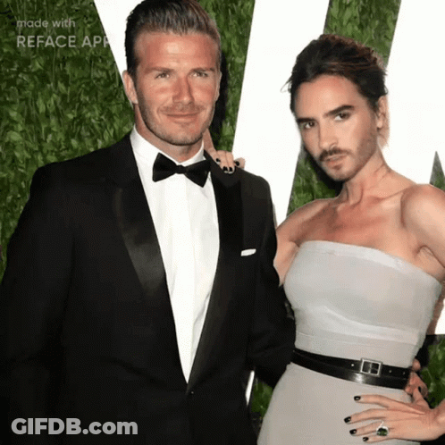 A Man In A Tuxedo And A Woman In A Strapless Dress Are Standing Next To Each Other GIF