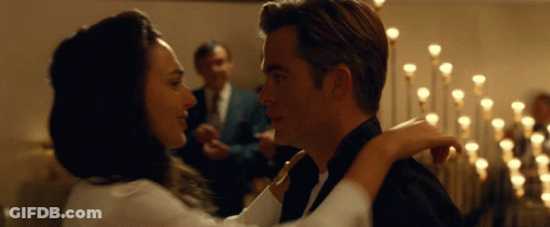 A Man In A Tuxedo And A Woman In A White Shirt Are Dancing GIF