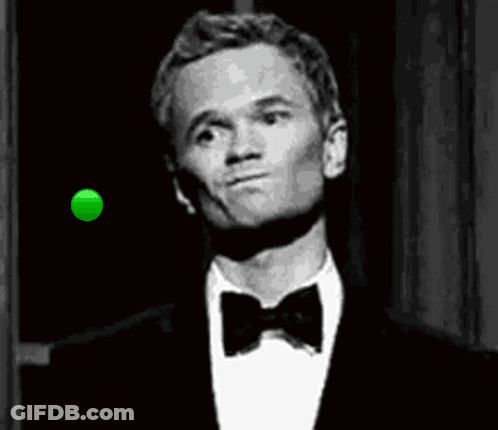 A Man In A Tuxedo And Bow Tie Is Looking At A Green Ball In The Air . GIF