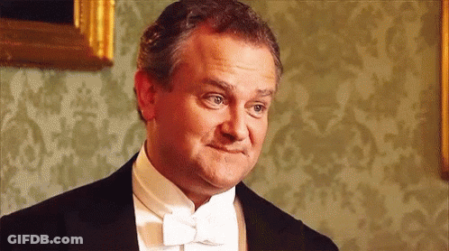A Man In A Tuxedo And Bow Tie Is Making A Silly Face . GIF
