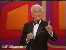 A Man In A Tuxedo And Bow Tie Is Speaking Into A Microphone GIF