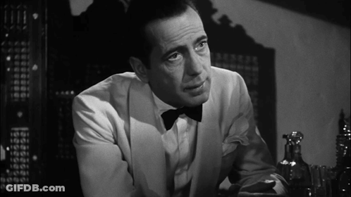 A Man In A Tuxedo And Bow Tie Looks At Something GIF