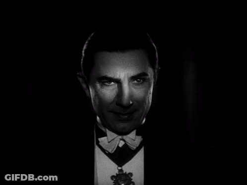 A Man In A Tuxedo And Bow Tie Looks At The Camera GIF