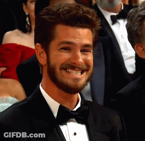 A Man In A Tuxedo And Bow Tie Smiles In A Crowd GIF