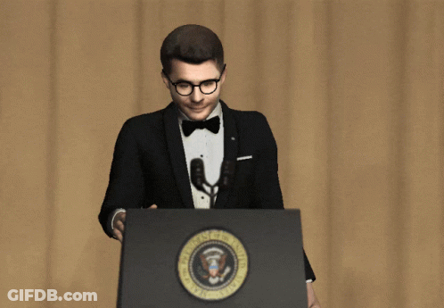 A Man In A Tuxedo And Bow Tie Stands At A Podium With The Seal Of The President Of The United States On It GIF