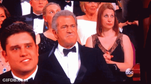 A Man In A Tuxedo And Bow Tie Stands In Front Of A Screen That Says Abc On It GIF