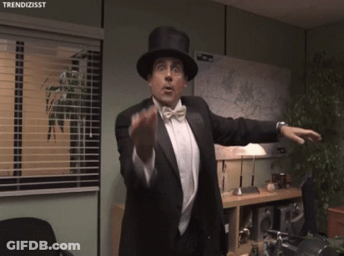 A Man In A Tuxedo And Top Hat Is Pointing A Gun With The Hashtag Trendizisst Below Him GIF