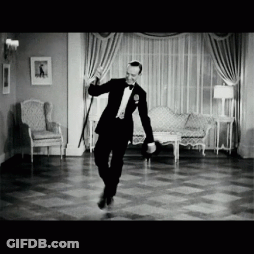 A Man In A Tuxedo Dancing In A Living Room GIF
