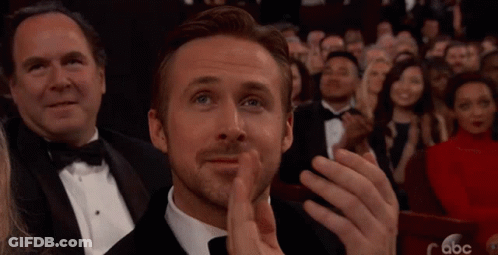 A Man In A Tuxedo Is Applauding While Sitting In A Crowd Of People . GIF