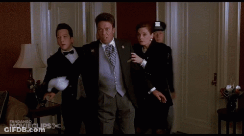 A Man In A Tuxedo Is Being Escorted By A Woman And A Man In A Police Uniform GIF