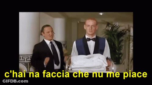 A Man In A Tuxedo Is Carrying A Stack Of Towels And The Caption Says C'hai Na Faccia GIF