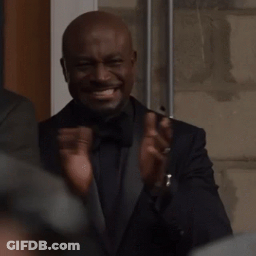 A Man In A Tuxedo Is Clapping His Hands And Making A Funny Face . GIF