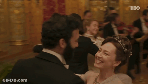 A Man In A Tuxedo Is Dancing With A Woman In A White Dress With A Hbo Logo In The Background . GIF
