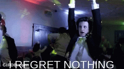 A Man In A Tuxedo Is Dancing With His Arms In The Air And The Words I Regret Nothing Below Him . GIF