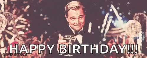 A Man In A Tuxedo Is Holding A Glass Of Champagne And Says Happy Birthday !!! GIF