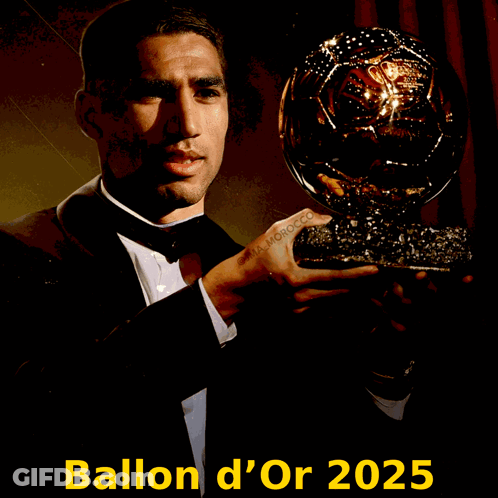 A Man In A Tuxedo Is Holding A Trophy That Says Ballon D' Or 2025 On The Bottom GIF