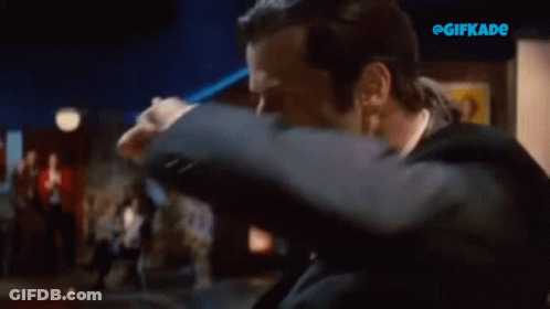 A Man In A Tuxedo Is Making A Peace Sign With His Hands GIF