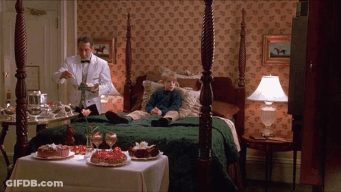 A Man In A Tuxedo Is Serving A Dessert To A Boy In A Hotel Room GIF