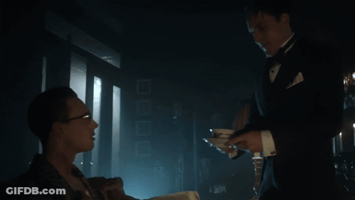 A Man In A Tuxedo Is Serving A Man In A Suit GIF