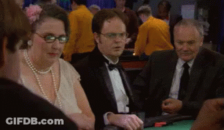 A Man In A Tuxedo Is Sitting At A Table With Other People Playing Poker . GIF