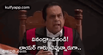 A Man In A Tuxedo Is Sitting In A Chair Holding A Gavel And Giving A Thumbs Up . GIF
