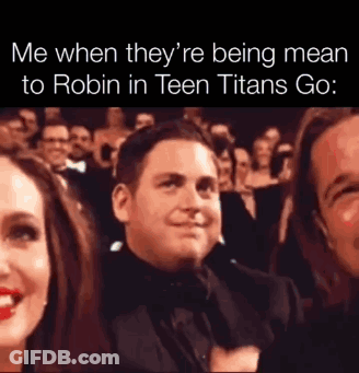 A Man In A Tuxedo Is Sitting In Front Of A Crowd . GIF