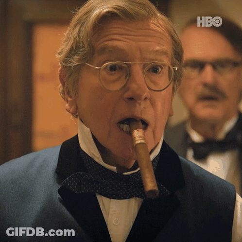 A Man In A Tuxedo Is Smoking A Cigar With The Hbo Logo In The Corner GIF