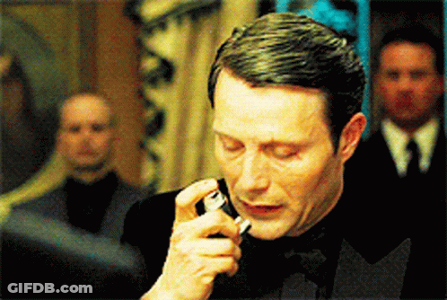 A Man In A Tuxedo Is Smoking A Cigarette In A Room GIF