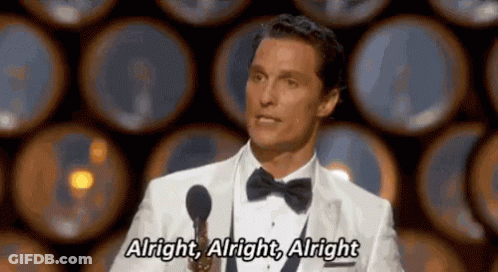 A Man In A Tuxedo Is Speaking Into A Microphone And Saying Alright , Alright , Alright GIF