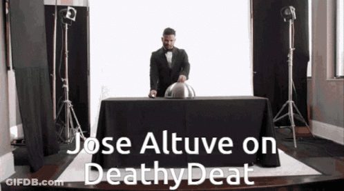 A Man In A Tuxedo Is Standing Behind A Table With The Words Jose Altuve On Deathy Deat Written On It GIF