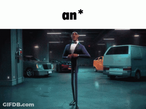A Man In A Tuxedo Is Standing In A Parking Garage With Cars And The Word An * Above Him GIF