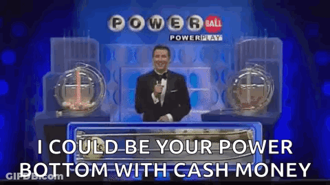 A Man In A Tuxedo Is Standing In Front Of A Power Ball Lottery Machine . GIF