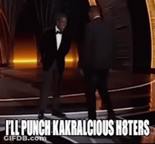 A Man In A Tuxedo Is Standing Next To Another Man With The Words " I 'Ll Punch Kakralicious Hoters " GIF