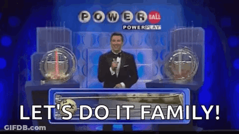 A Man In A Tuxedo Is Standing On A Stage In Front Of A Powerball Lottery Machine . GIF