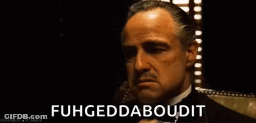 A Man In A Tuxedo Is Talking On A Cell Phone And Says Fuhgeddaboutit . GIF