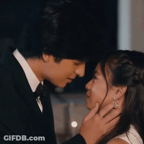 A Man In A Tuxedo Is Touching A Woman 'S Face GIF